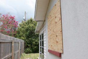 A home with plywood covering the window in preparation for a hurricane.